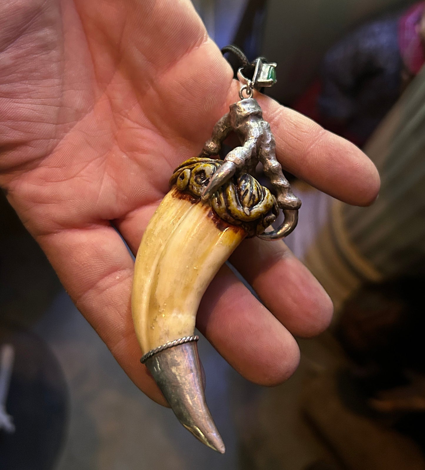 Pendentif dent de lion sertie d'une patte en argent.