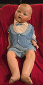 Poupée antique garçon joufflu en tenue bleue pâle