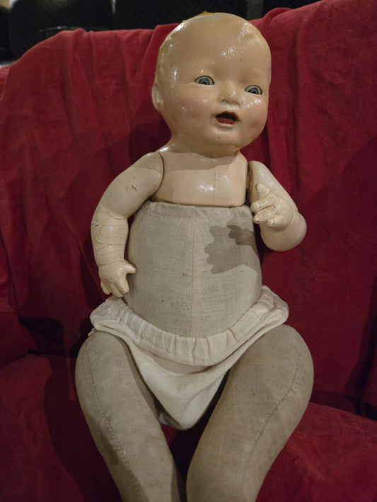 Poupée antique en porcelaine et en tissu.