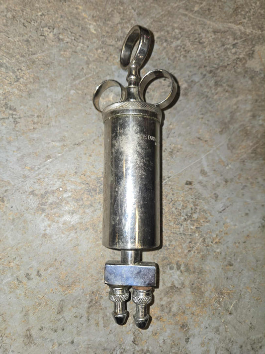 Ancienne seringue en métal pour embaumement